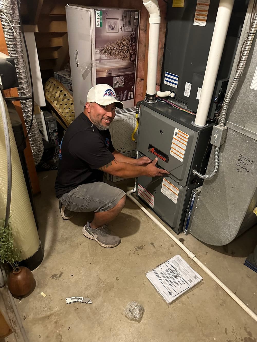 Technician servicing HVAC system in basement, ensuring optimal performance and safety.