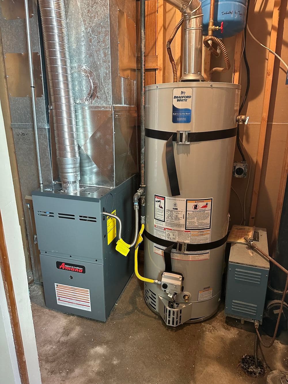 Furnace and water heater in a utility room, showcasing efficient home heating systems.