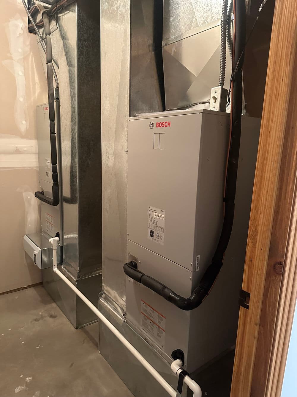 Bosch heating system installed in a basement with ductwork and piping visible.