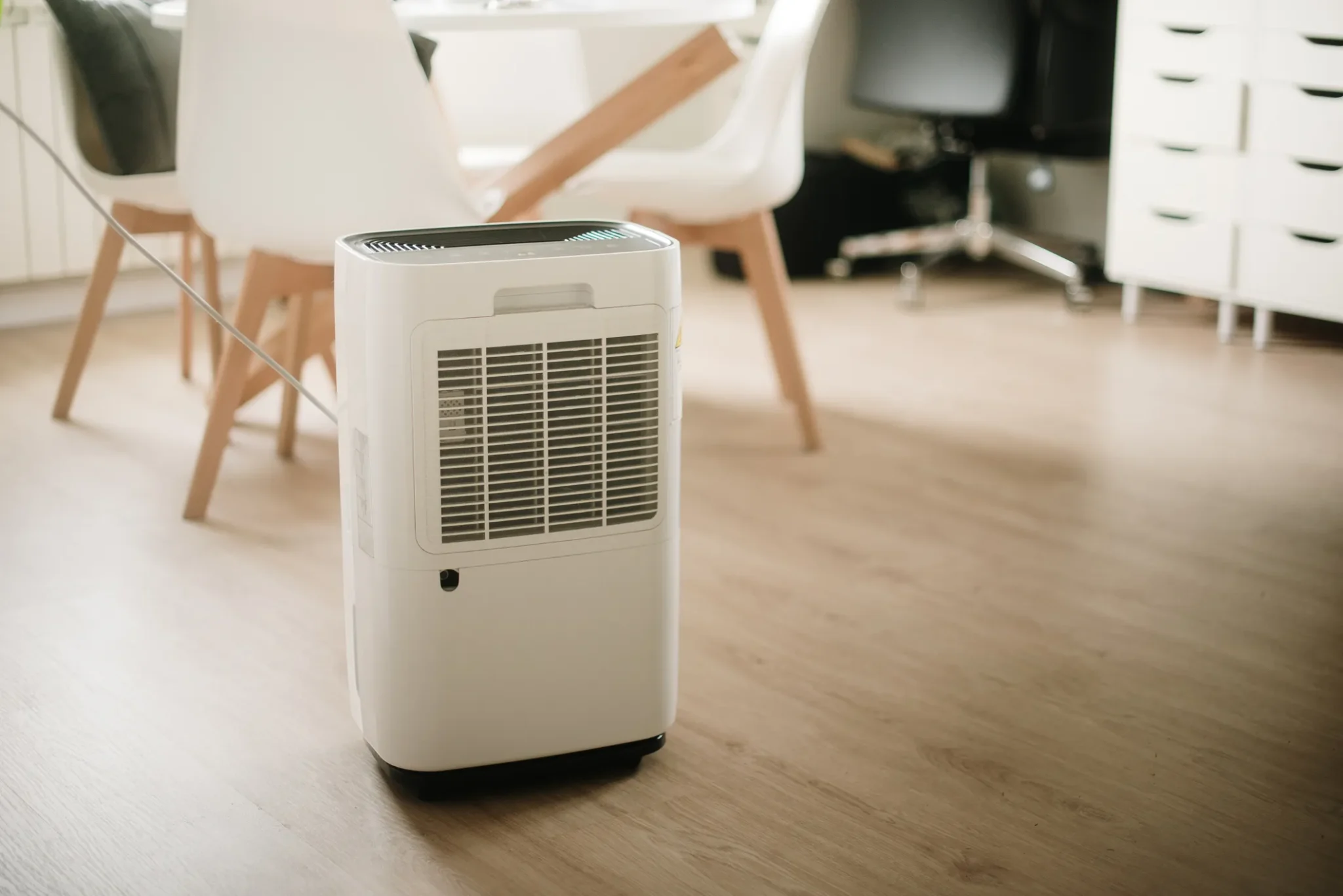 Whole Home Dehumidifiers In West Jordan, UT 1 A white dehumidifier is positioned on a wooden floor.
