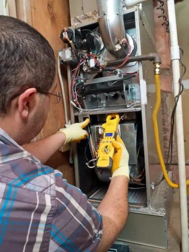 Furnacerepair2 A technician maintaining a furnace installed inside the house
